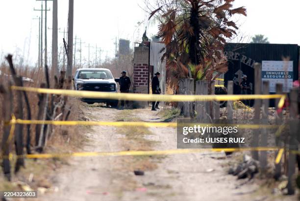 Security forces stand guard while members of the collective "Guerreros Buscadores" visit the Izaguirre ranch, where on March 5 they located three...
