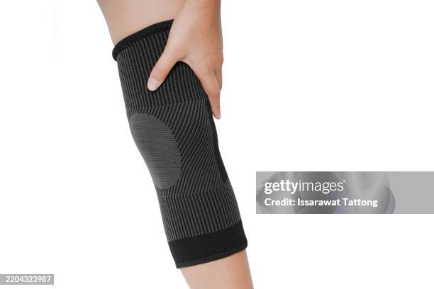 A Person Is Holding Their Knee And Wearing A Knee Brace, 照片檔
