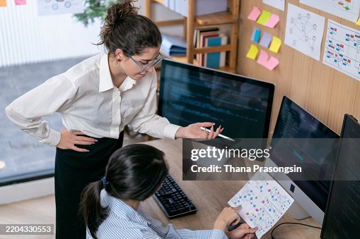 Software programmers analyzing html code and database, brainstorming script ideas to develop new security system. Software programmers analyzing html code and database, brainstorming script ideas to develop new security system.