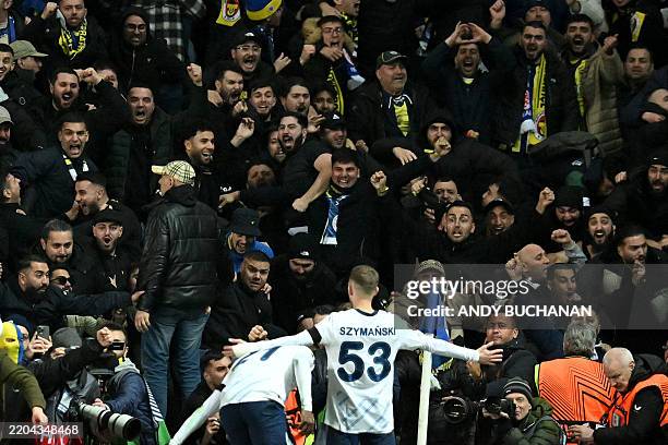 Fenerbahce fans celebrate the teams second goal with Fenerbahce's Polish midfielder Sebastian Szymanski during the UEFA Europa League second-leg...
