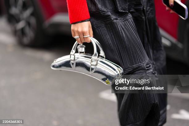 Guest wears a shiny silver metallic leather bag, outside Ottolinger, during the Paris Fashion week Women's Fall/Winter 2025-2026 on March 9, 2025 in...