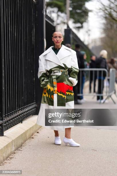 Carla Ginola wears dark green shirt, white dark green bright cherry red dark yellow pattern/print belted Lacoste trench coat, white pointed toe...