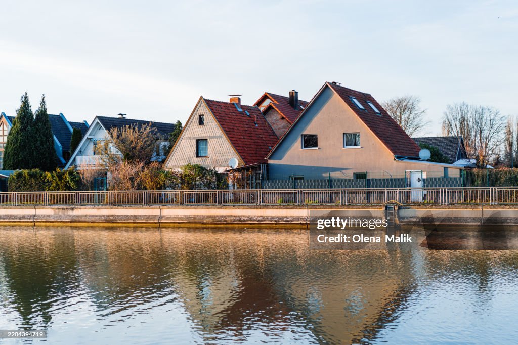 Scenic Riverside Homes with Reflections in the Tranquil Water During Sunset