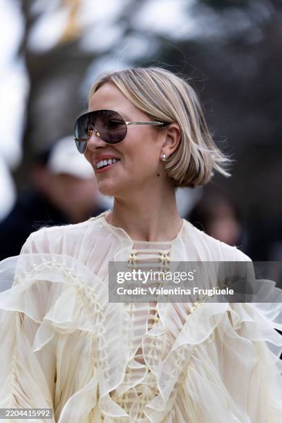 Violet Grace Atkinson wears silver earrings, black sunglasses and a light yellow ruffles embroidered and knitted ruffles long maxi dress outside...