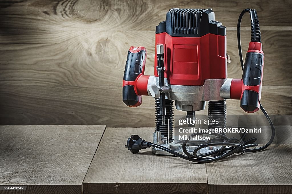 Red speed variable power small plunge router milling machine portable electric hand mini wood router on vintage wooden background