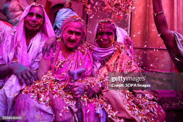 Indian Widows throw colorful powders and flower petals at each other as they dance during a celebration of Holi or 'festival of colors' at Gopinath...