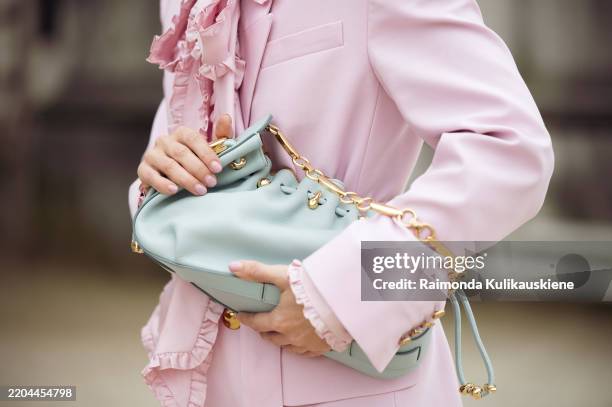 Irina Kro Eicke wears pink suit, wide pants and blazer with a belt and bow tie and mint green bag outside the Zimmermann fashion show during the...