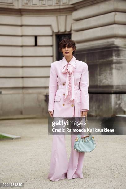 Irina Kro Eicke wears pink suit, wide pants and blazer with a belt and bow tie and mint green bag outside the Zimmermann fashion show during the...