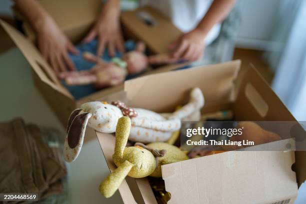 sorting and packing toys for donation - sharing economy stock-fotos und bilder