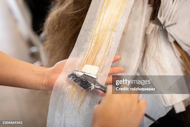 junge friseurinnen, die eine blondierungsbehandlung an den haaren eines kunden durchführen - ombré hair stock-fotos und bilder
