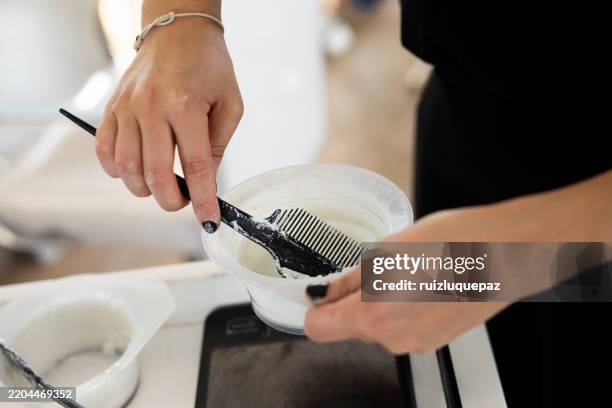 female hairdresser's hands preparing the formula for hair bleaching - bleaching hair photos et images de collection