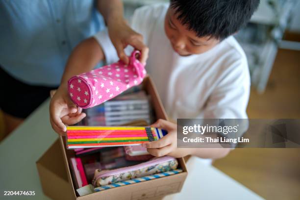 mother and son organizing school supplies for donation - school supplies stock pictures, royalty-free photos & images