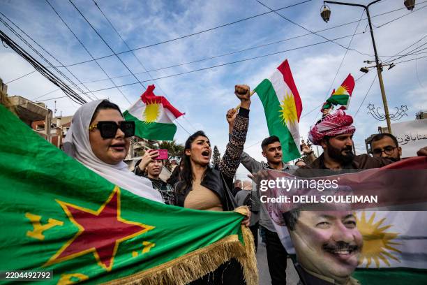 Syrian Kurds chant slogans and wave flags as they demonstrate in the northeastern city of Qamishli on March 14 against the new constitutional...