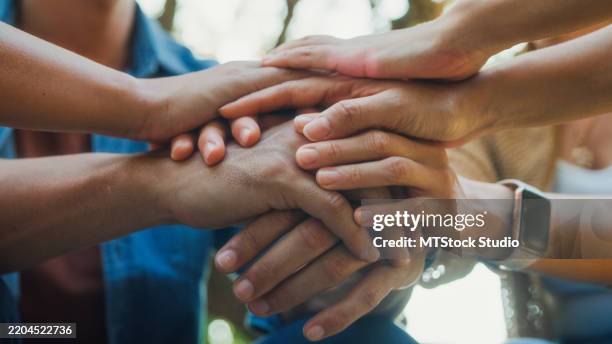 closeup diverse group people engaging in supportive group therapy session, sharing personal stories and advice to promote mental health and recovery in park. mental health community concept. - gemeindezentrum stock-fotos und bilder