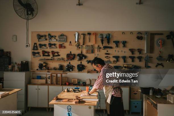 artisanat asiatique chinois charpentier senior utilisant une ponceuse polissage pièce de bois dans l’atelier de menuiserie - établi photos et images de collection