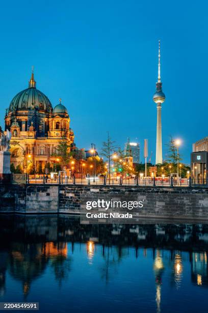 berlin cathedral and tv tower illuminated at dusk reflecting in the river - berlin panorama stock pictures, royalty-free photos & images