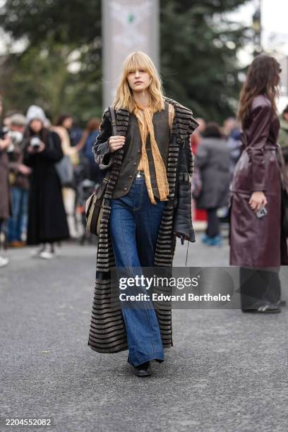 Guest wears dark orange yellow pattern/print long sleeve shirt, shiny dark gray tailored leather vest, shiny black faux fur lined leather coat, light...