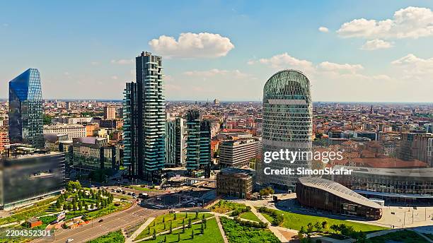 modern skyscrapers and green spaces in milan's porta nuova district under bright blue sky - milan stock pictures, royalty-free photos & images