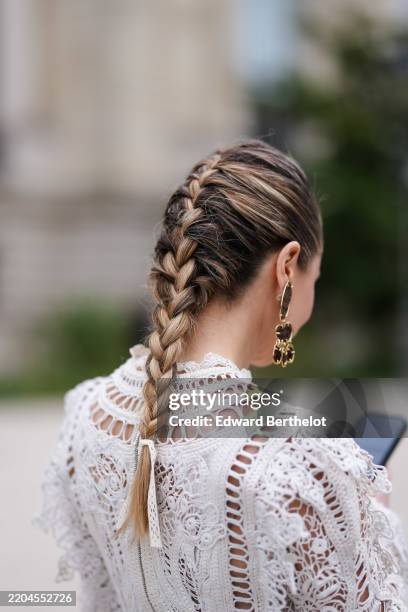 Julia Comil wears french braid, dark brown earrings, white sheer mesh lace long sleeve cropped Zimmermann shirt, outside Zimmermann, during the Paris...