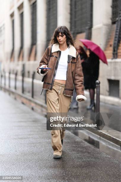 Guest wears white t-shirt, dark brown shiny black pattern cream faux fur collar oversized suede jacket, shiny black leather bag, light brown cargo...