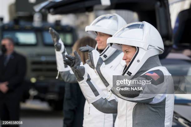 In this NASA handout, NASA astronauts Anne McClain, right, and Nichole Ayers gesture to friends and family as they prepare to depart the Neil A....
