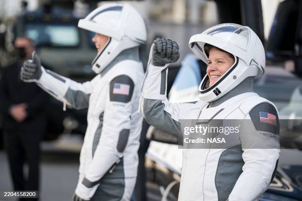 In this NASA handout, NASA astronauts Anne McClain, right, and Nichole Ayers gesture to friends and family as they prepare to depart the Neil A....