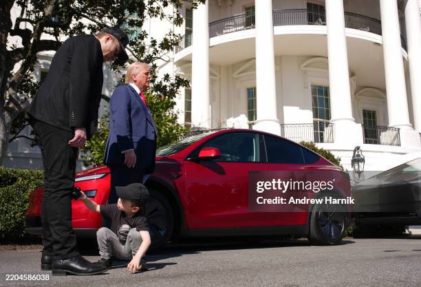Xii, the son of White House Senior Advisor, Tesla and SpaceX CEO Elon Musk, plays with a toy car as Musk and U.S. President Donald Trump speak...