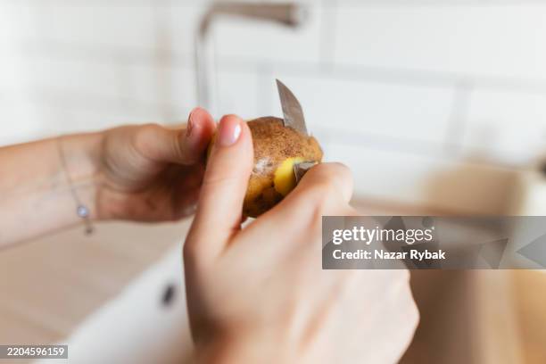 woman's hands carefully scalloped potatoes - aardappelgratin aardappel stockfoto's en -beelden