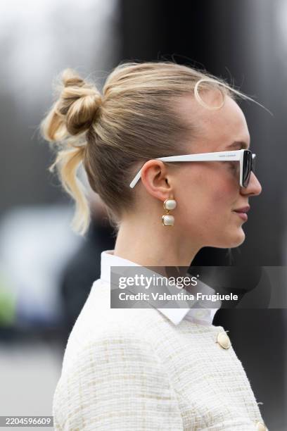 Guest wears white sunglasses, pearl earrings, a white shirt and a white tweed jacket outside Chanel show during the Womenswear Fall/Winter 2025/2026...