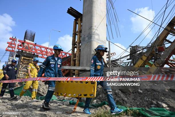 Emergency rescue workers carry a stretcher at the site of a crane collapse at a construction site along Rama II highway in Bangkok on March 15, 2025....