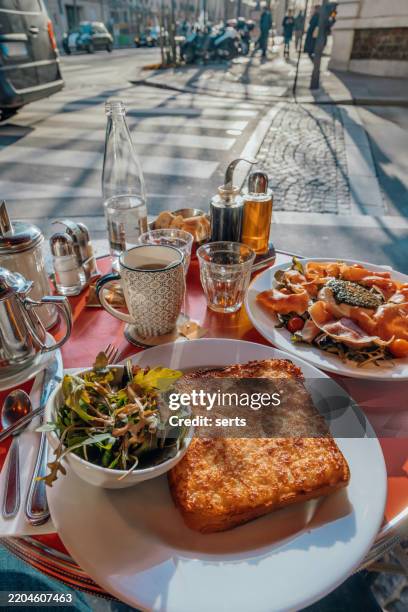 delicious french breakfast at a sidewalk café in paris, france - croque monsieur stockfoto's en -beelden