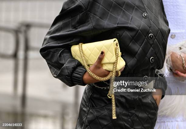 Guest is seen wearing a black Chanel jacket and shorts with a yellow and gold Chanel bag outside the Chanel show during the Womenswear Fall/Winter...