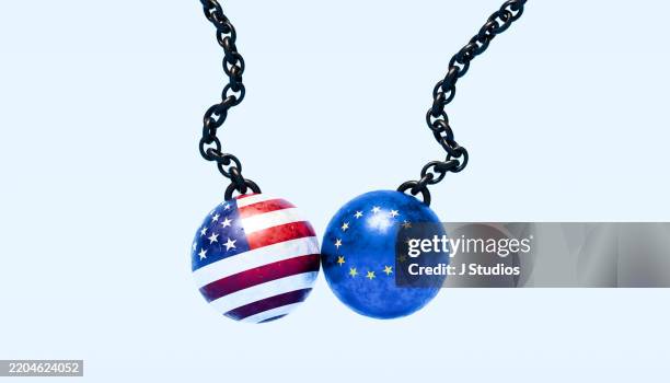 transatlantic clash: wrecking balls in american and eu flag colors - european union flag stock pictures, royalty-free photos & images