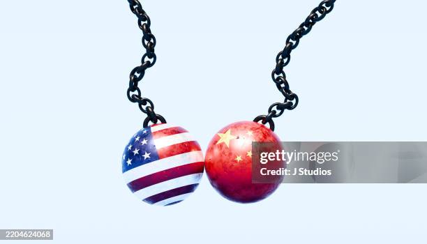 trade wars in motion: wrecking balls in american and chinese flag colors - aranceles fotografías e imágenes de stock