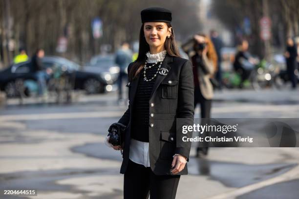 Guest wears black hat, kaclet, pearl necklace, bag, white blouse, pantsoutside Chanel during the Womenswear Fall/Winter 2025/2026 as part of Paris...