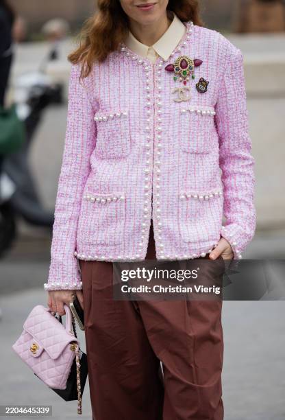 Guest wears pink jacket with rhinestones, bag, rust brown pants outside Chanel during the Womenswear Fall/Winter 2025/2026 as part of Paris Fashion...
