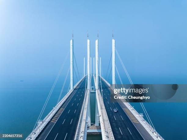 drone point view of jiaozhou bay bridge of qingdao in the mist - cable stayed bridge stock pictures, royalty-free photos & images