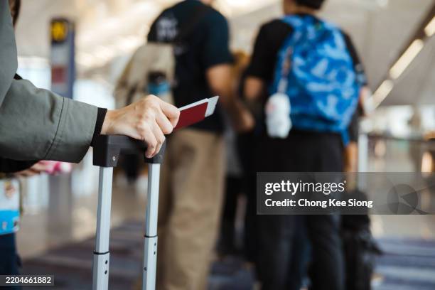 ready for travelling: an unrecognizable asian holding her passport and other documents - douane stockfoto's en -beelden