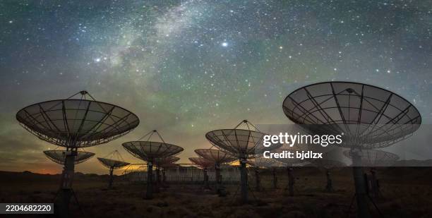 array di antenne satellitari sotto il cielo della via lattea - esplorazione dello spazio foto e immagini stock