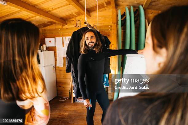 smiling surfer explains strategy on whiteboard to his students - surf school stock pictures, royalty-free photos & images