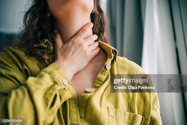 woman suffering from sore throat holding her neck - dor de garganta - fotografias e filmes do acervo