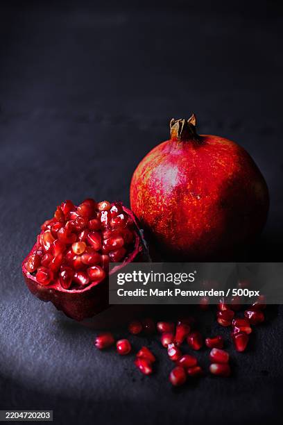 close-up of pomegranates on table - pomegranate stock pictures, royalty-free photos & images