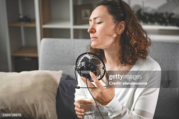 woman suffering from heatstroke at home - hyperthermia stock pictures, royalty-free photos & images