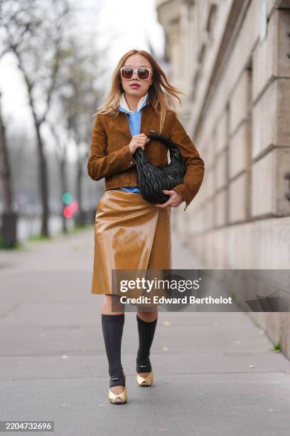 Niki Wu Jie wears white sunglasses, white collar buttoned up long sleeve Miu Miu shirt, light blue buttoned up long sleeve Miu Miu shirt, dark brown...