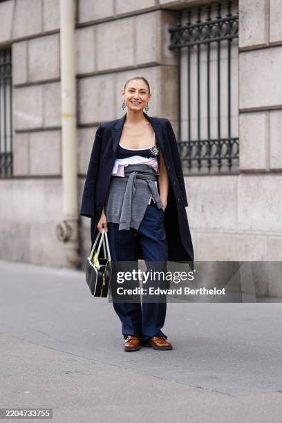 Guest wears silver earrings, black Miu Miu tank top, white unbuttoned Miu Miu shirt, light pink unbuttoned Miu Miu shirt, dark gray strapless knit...