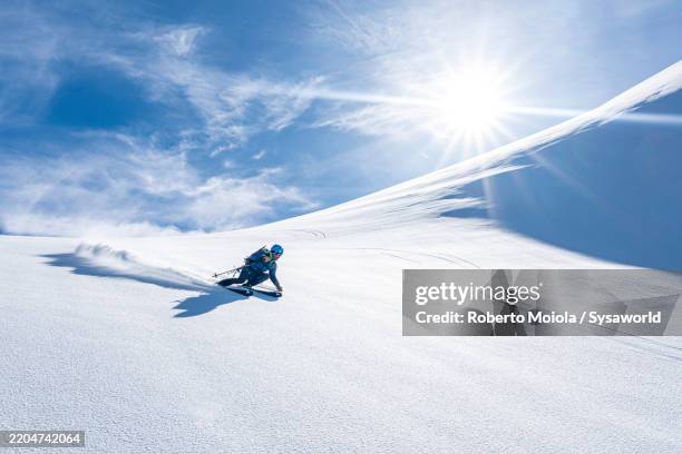 man enjoying downhill skiing on snowy mountains - adrenalin stock-fotos und bilder