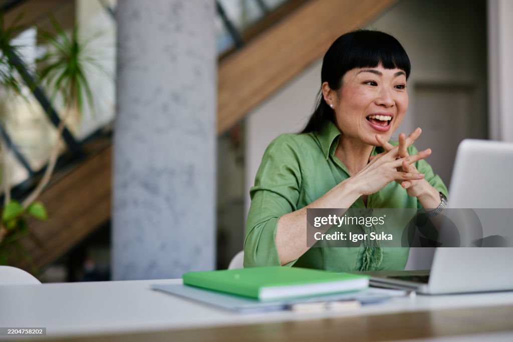 Enthusiastic japanese businesswoman having a video call on laptop