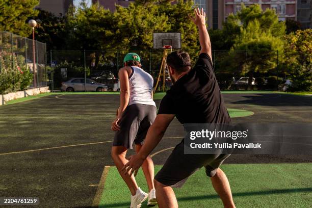 basketball players competing on outdoor court - dueling stock pictures, royalty-free photos & images