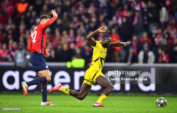 Serhou Guirassy of Borussia Dortmund is challenged by Thomas Meunier of LOSC Lille which results in Match Referee Sandro Scharer awarding a penalty...