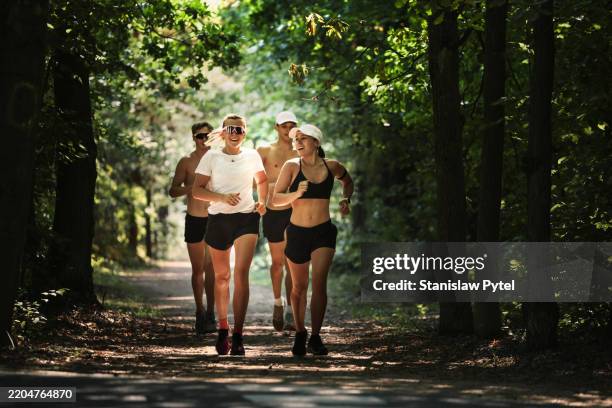 female and male pentathletes running during laser run team training for international level competition, forest - correr fotografías e imágenes de stock
